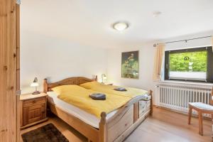 a bedroom with a large bed with yellow sheets and a window at Ferienwohnung Sunnenviul in Lennestadt