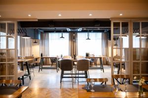 a dining room with tables and chairs and windows at Hotel Park in Široki Brijeg