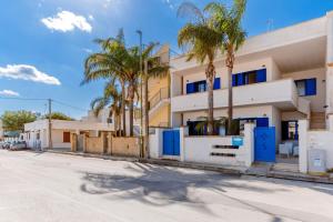 a building with palm trees in front of a street at B&B Gioia del Mare in Torre Lapillo +21 photos