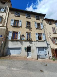 an old building with doors and windows on a street at La Flûte 2 in Thiers
