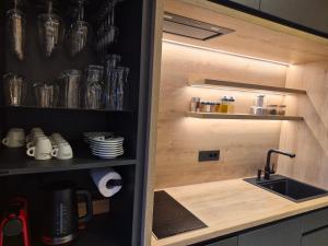 a kitchen with a sink and a shelf with dishes at Kabata 2620 ` Кабата 2620 in Bansko