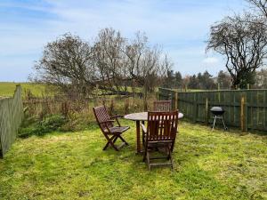 two chairs and a table in a yard with a fence at Woodpecker Hollow - Uk45980 in Ebchester