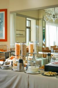 a table with plates of food in front of a mirror at Hotel Italie et Suisse in Stresa
