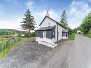 a small white house on the side of a road at Tigh Na Clachan in Clachan