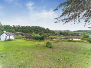 an open field with a house and a bridge at Tigh Na Clachan in Clachan
