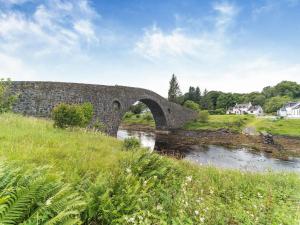 a stone bridge over a river in a field at Tigh Na Clachan in Clachan
