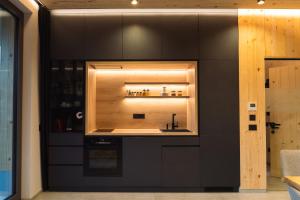 a kitchen with black cabinets and a sink at Kabata 2620 ` Кабата 2620 in Bansko