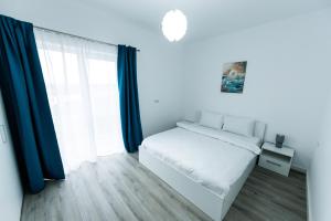 a white bedroom with a bed and a window at VISAJ Nova in Timişoara +55 photos