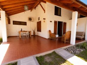 a patio with a table and chairs and a house at Tala in Villa Cura Brochero