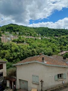 a white house with a mountain in the background at La Flûte 2 in Thiers