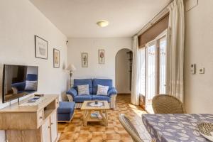 a living room with blue furniture and a tv at Bahia Studio in Empuriabrava