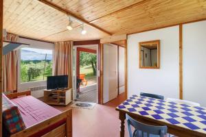 a living room with a dining room table and a television at Chalet Le Chene Vert in Salignac Eyvigues