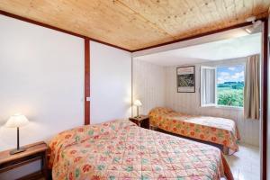 a hotel room with two beds and a window at Chalet Le Chene Vert in Salignac Eyvigues +16 photos