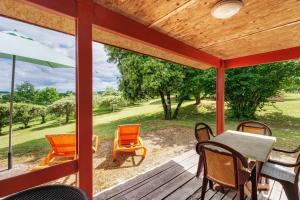 a porch with a table and chairs and a view of a field at Chalet Le Chene Vert in Salignac Eyvigues