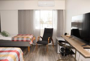 ein Hotelzimmer mit Bett, Schreibtisch und Stühlen in der Unterkunft Hotel Sommelo in Kouvola