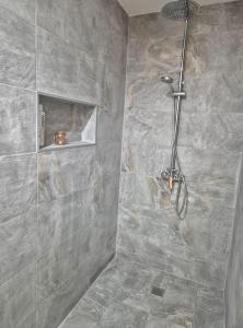 a bathroom with a shower with gray tiles at Casa en Cotillo Lagos with Free Wifi & Netflix in El Cotillo +50 photos