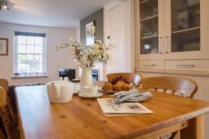 a wooden table with a plate of food on it at Stuckie Ben, Southwold in Southwold