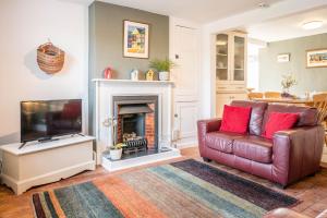 a living room with a couch and a television at Stuckie Ben, Southwold in Southwold