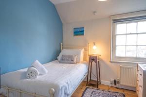 a bedroom with a bed with a blue wall at Stuckie Ben, Southwold in Southwold