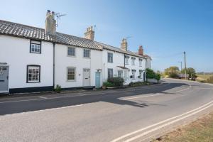 a row of white houses on a road at Stuckie Ben, Southwold in Southwold