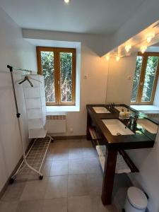 a bathroom with two sinks and a large mirror at La Gabare 1 in Thiers