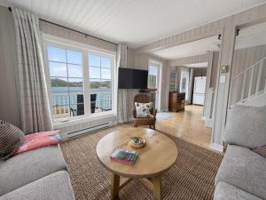 a living room with a couch and a table at Seaside Serendipity Cottage in Herring Neck