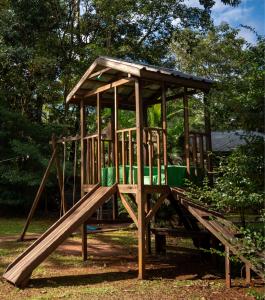 a wooden playground with a slide in a park at El Descanso Iguazú by DOT Cabana in Puerto Iguazú