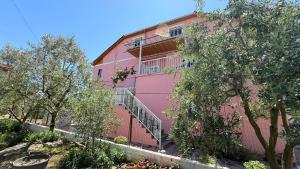 a pink building with stairs in front of it at Fori Vodo in Divjakë