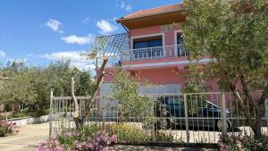 a pink house with a fence in front of it at Fori Vodo in Divjakë +38 photos