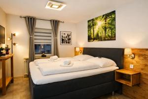 ein Schlafzimmer mit einem großen Bett mit weißer Bettwäsche in der Unterkunft Gasthof Sonnental in Winterberg