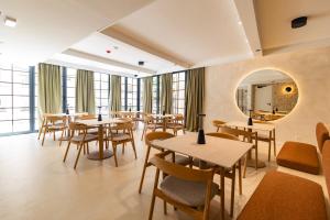 a restaurant with tables and chairs and a mirror at Hidden Tree Heritage Hotel in Zadar