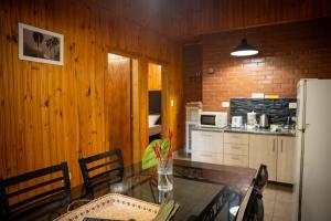 a kitchen with a glass table and a refrigerator at El Descanso Iguazú by DOT Cabana in Puerto Iguazú