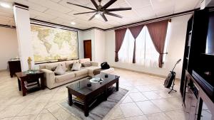 a living room with a couch and a tv at Galapagos Family Vacation 3 bedrooms 7 guests Centrally located and ocean view in Puerto Ayora