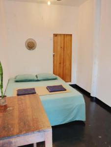 a bedroom with a bed and a wooden door at Arugam Bay Beach House in Pottuvil