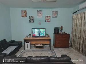a living room with a couch and a desk with a tv at Homestay Dasuqi #Musl!m only in Seremban
