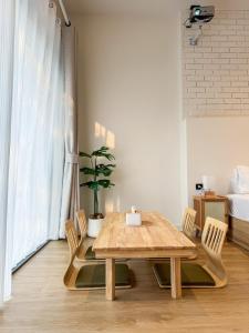 a dining room with a wooden table and chairs at Common Living Iconsiam in Bangkok