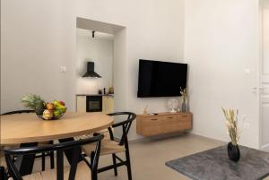 a living room with a table and a television on a wall at Gioma Luxury Villas in Agios Nikolaos
