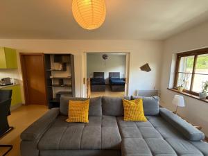 a living room with a gray couch with yellow pillows at Industriel F3 Appartement in Thann