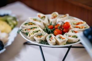 a plate of sandwiches and tomatoes on a table at Grand Hotel Sava Superior in Rogaška Slatina