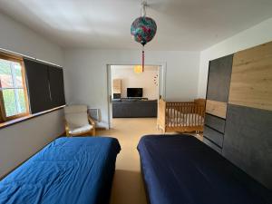 a bedroom with two beds and a crib and a living room at Industriel F3 Appartement in Thann