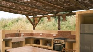 a kitchen with a sink and a stove top oven at Helder Farm Studios in São Teotónio