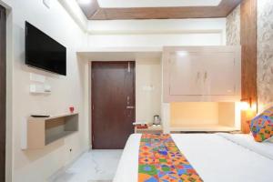 a bedroom with a bed and a flat screen tv at Fabhotel Grant Heights - Nr Biju Patnaik International Airport in Bhubaneshwar
