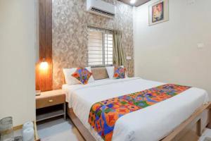 a bedroom with a large bed in a room at Fabhotel Grant Heights - Nr Biju Patnaik International Airport in Bhubaneshwar
