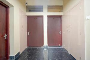a row of three doors in a room with black floor at Fabhotel Grant Heights - Nr Biju Patnaik International Airport in Bhubaneshwar +27 photos