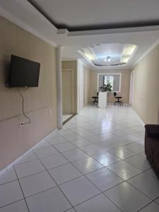 a living room with a flat screen tv on a wall at Kairos Pousada e Hostel in Cabo de Santo Agostinho
