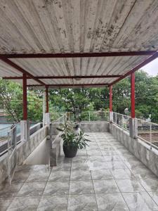 a patio with a roof with a potted plant on it at Kairos Pousada e Hostel in Cabo de Santo Agostinho