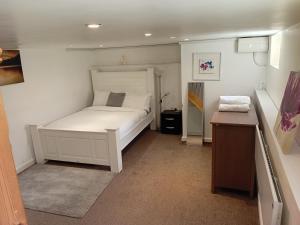 a small bedroom with a white bed and a desk at Shetcliffe Lodge in Dudley Hill