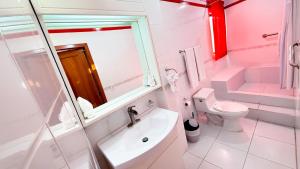 a pink bathroom with a sink and a toilet at Galapagos Family Vacation 3 bedrooms 7 guests Centrally located and ocean view in Puerto Ayora +69 photos