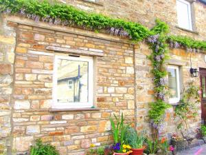 a stone building with plants on the side of it at Hazels Roost in Bainbridge