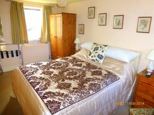 a bedroom with a bed with a brown and white blanket at Hazels Roost in Bainbridge